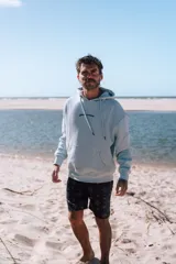 Hoodie celeste claro con capucha y estampado en la espalda que dice "glassy surfer RIDE YOUR OWN WAVE" en color azul oscuro.