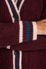 Cardigan de punto color bordó con diseño oversize, cuello en V y cierre frontal con botones. Presenta detalles de rayas en contraste en color crema y azul en los bordes, puños y ruedo, además de dos bolsillos frontales aplicados.