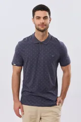 Remera polo de manga corta en color azul marino, con estampado sutil de pequeños motivos geométricos, cuello camisero y cartera con tres botones.
