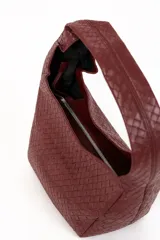 Cartera tipo hobo de cuero sintético bordó, con diseño trenzado y asa integrada.