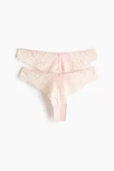Pack de dos bombachas estilo Brazilian de tiro bajo, confeccionadas en malla translúcida y encaje floral en tonos rosados, con detalle de pequeño moño en la cintura.