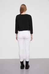 Pantalon jean de corte skinny y calce medio, color blanco, con bolsillos laterales y traseros.
