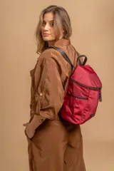 Mochila urbana de diseño compacto en color negro, confeccionada en nylon resistente. Cuenta con un compartimento principal con cierre, bolsillo frontal con cierre y correas ajustables con detalle de marca.