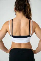 Top deportivo blanco con doble tela y tirantes finos.