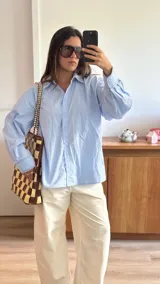 Bolso tipo tote de cuero trenzado a mano con diseño de damero en colores marrón y beige. Cuenta con doble asa trenzada y forro interior.