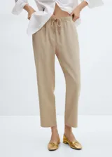Pantalon de corte jogger confeccionado en tejido fluido, con cintura elástica y lazo ajustable. Presenta diseño largo y dos bolsillos laterales.