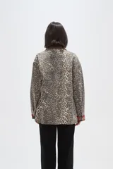 Campera de jean con estampado animal print, cuello de pana en color marrón, cierre frontal con botones metálicos, bolsillos frontales con solapa y puños con detalle de tela escocesa en tonos rojos y azules.