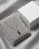 Collar de acero con cadena fina y dije rectangular con circonia color azul profundo en engaste biselado.