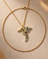 Collar de bronce dorado con cadena fina y dije en forma de colibrí esmaltado en tonos celestes y negros, con incrustaciones de circonias y un ojo turco en el centro.