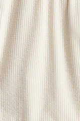 Short de baño de sirsaca con diseño a rayas verticales en tonos beige y blanco. Cuenta con cintura elástica con cordón ajustable, bolsillos laterales, bolsillo trasero con cierre autoadherente y suspensor interior de malla.