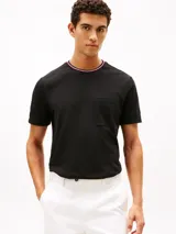 Remera de manga corta Tommy Hilfiger confeccionada en tejido de piqué de algodón. Presenta un diseño de corte regular con cuello redondo acentuado por ribetes tricolores y un bolsillo de parche en el pecho.