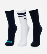 Pack de tres pares de medias deportivas Puma de caña larga. Incluye dos pares en color azul marino, uno con logo de la marca en turquesa en la puntera, y un par blanco con dos franjas horizontales oscuras y logo Puma en el empeine.