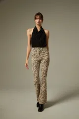 Pantalon de jean con corte flare y tiro alto, estampado con diseño animal print de leopardo en tonos marrones. Cuenta con bolsillos funcionales y ruedo desflecado.