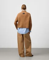 Sweater de punto en color tostado con cuello chimenea y mangas raglán, confeccionado en una mezcla de lana merino y alpaca que le otorga una textura suave y abrigada.