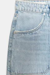 Bermuda de tiro alto en denim celeste lavado, estilo carpintero, con grandes bolsillos frontales superpuestos y trabilla lateral.