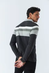 Remera polo de manga larga con diseño a rayas horizontales en tonos negro, gris y blanco. Logo de la marca Mistral bordado en el pecho.