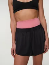 Short deportivo negro con cintura ancha elastizada de color rosado y aberturas laterales.