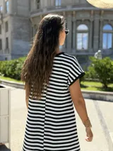 Vestido largo tejido a rayas horizontales blancas y negras, de corte holgado con tajo lateral.