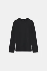 Camiseta de manga larga confeccionada en tejido de punto interlock elástico y flexible, con cuello redondo y bajo recto.