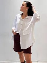 Camisa negra de manga larga con cuello clásico y cierre frontal con botones.