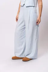Pantalón sastrero de lino color blanco, de corte ancho y tiro alto.