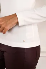 Remera de manga larga ajustada al cuerpo, con cuello redondo, confeccionada en una mezcla de algodón y elastano que aporta suavidad y elasticidad.