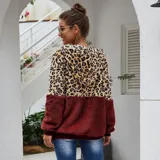 Campera tipo polar con cierre frontal, diseño combinado con estampado animal print en la parte superior y tejido de peluche blanco en la parte inferior. Cuenta con capucha con cordones ajustables y dos bolsillos frontales.