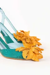 Zapato de tacón turquesa con diseño en escamas y flor naranja en la punta. Tacón de 6,5 cm, plantilla celeste, interior de piel y suela de cuero. Fabricado en España.