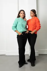 Buzo de lana color coral con diseño de tejido trenzado, cuello redondo y mangas largas.
