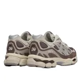Championes Asics modelo Gel-Nyc, en combinación de tonos marrón, gris y detalles plateados. Presentan diseño técnico con malla transpirable, refuerzos sintéticos y suela amortiguada.