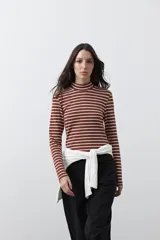 Polera de cuello alto con diseño de rayas horizontales en color azul marino sobre fondo blanco, confeccionada en tejido de punto con mangas largas.