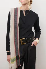 Remera de manga larga en color rosado, con cuello redondo y cierre frontal parcial con botones. Presenta un diseño de corte recto y estilo minimalista.