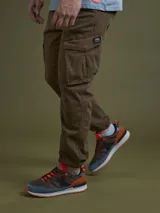 Pantalón cargo marrón con bolsillos laterales con fuelle y etiqueta con logo en el bolsillo.