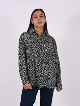Camisa de manga larga con estampado abstracto en blanco y negro, con cuello clásico y cierre frontal con botones. Corte holgado.