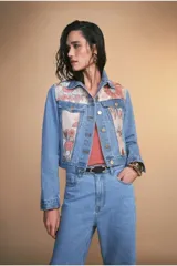 Chaqueta de jean azul claro con paneles de tela estampada con flores en el frente.