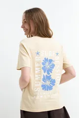 Remera celeste de manga corta con estampa en la espalda de flores y la leyenda "Summer Surf Sessions".