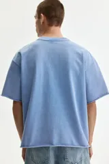 Remera de algodón de punto liviano, color celeste, con corte oversized, hombros caídos, cuello redondo acanalado y mangas cortas.