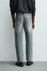 Jeans de corte recto y tiro medio confeccionados en denim de algodón con efecto lavado, diseño de cinco bolsillos y cierre frontal con cremallera y botón.