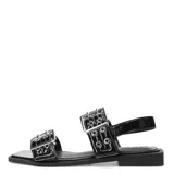 Sandalias planas Miss Carol modelo Kelmo, color negro, con tiras anchas ajustables mediante hebillas metálicas y detalle de ojales. Presentan una suela baja y punta cuadrada.