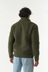Campera de sherpa con paneles en contraste de color azul marino en el pecho y cuello alto. Cuenta con cierre frontal completo, bolsillos laterales y un bolsillo frontal con cierre, confeccionada en tejido de poliéster.