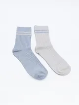 Pack de dos pares de medias de caña media, una celeste y otra gris claro, ambas con rayas horizontales en el borde superior.