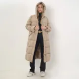 Campera tipo puffer larga con capucha, confeccionada en poliéster acolchado. Presenta cierre frontal doble con botones, bolsillos laterales abiertos y diseño de costuras horizontales.