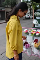 Camisa de corte oversize y diseño holgado, color mostaza, con cuello clásico y mangas largas con puños doblados.