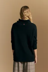 Polera de tejido de punto color naranja con cuello alto de caída relajada y diseño de líneas en relieve. Presenta una silueta holgada con hombros caídos y mangas largas.