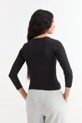 Remera de manga larga con cuello redondo a la base, confeccionada en algodón suave de corte ajustado.