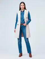 Chaleco largo color blanco roto, con cuello solapa, cierre frontal con botones dorados y bolsillos aplicados.