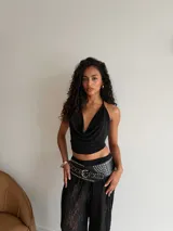 Cinturón ancho de estilo western confeccionado en cuero sintético negro, con múltiples hileras de tachas metálicas plateadas y hebilla central grande.