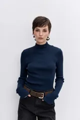 Blusa de punto acanalado en color azul marino, con cuello alto y mangas largas ajustadas.