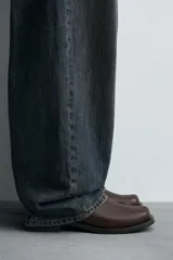 Bota de media caña con detalle de pespunte en la parte superior, cierre mediante cremallera lateral, horma cuadrada y suela a tono con ligero tacón.