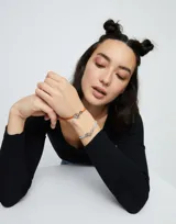 Pulsera de cuero trenzado color naranja con cierre de mosquetón entrelazado bañado en plata.